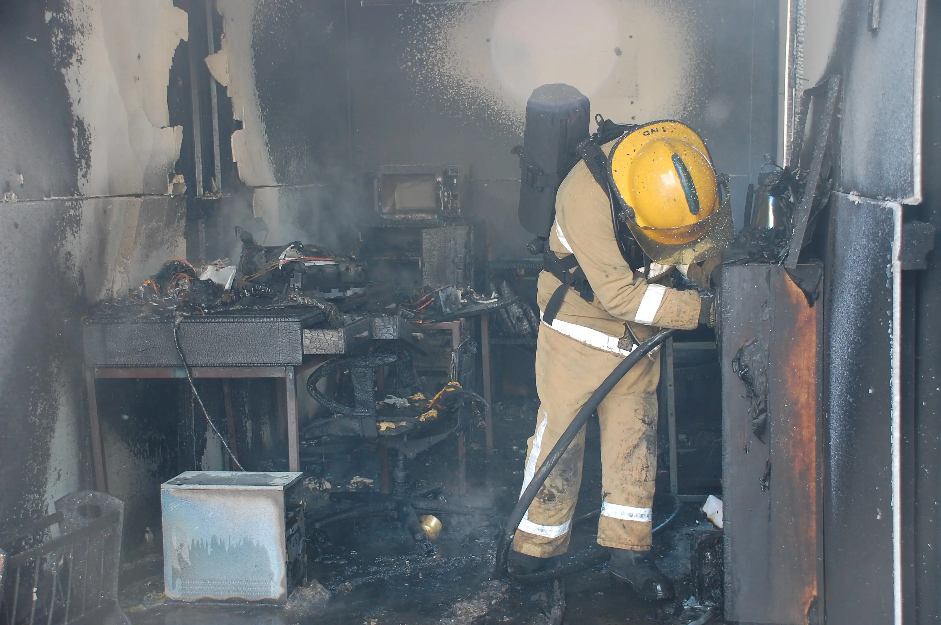 A fireman investigates a burnt building