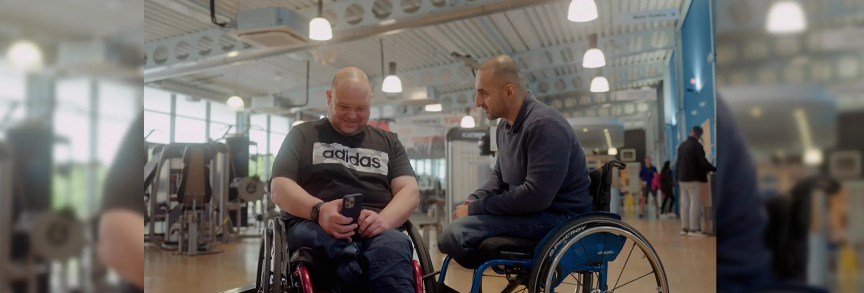 Two men in wheelchairs in a gym