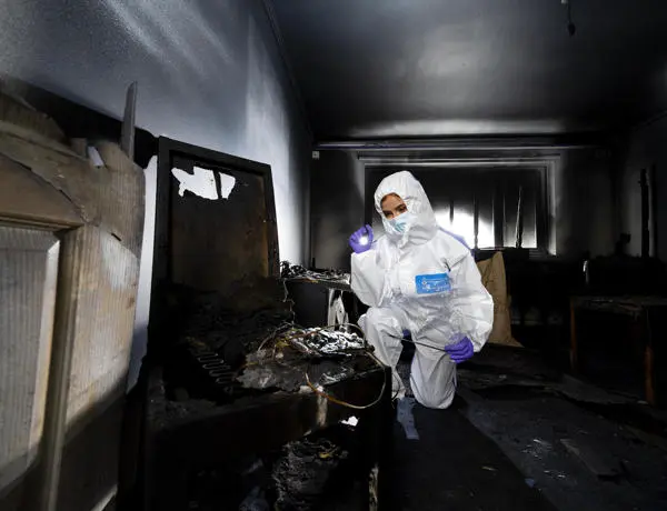 A student investigating in a fire damaged room