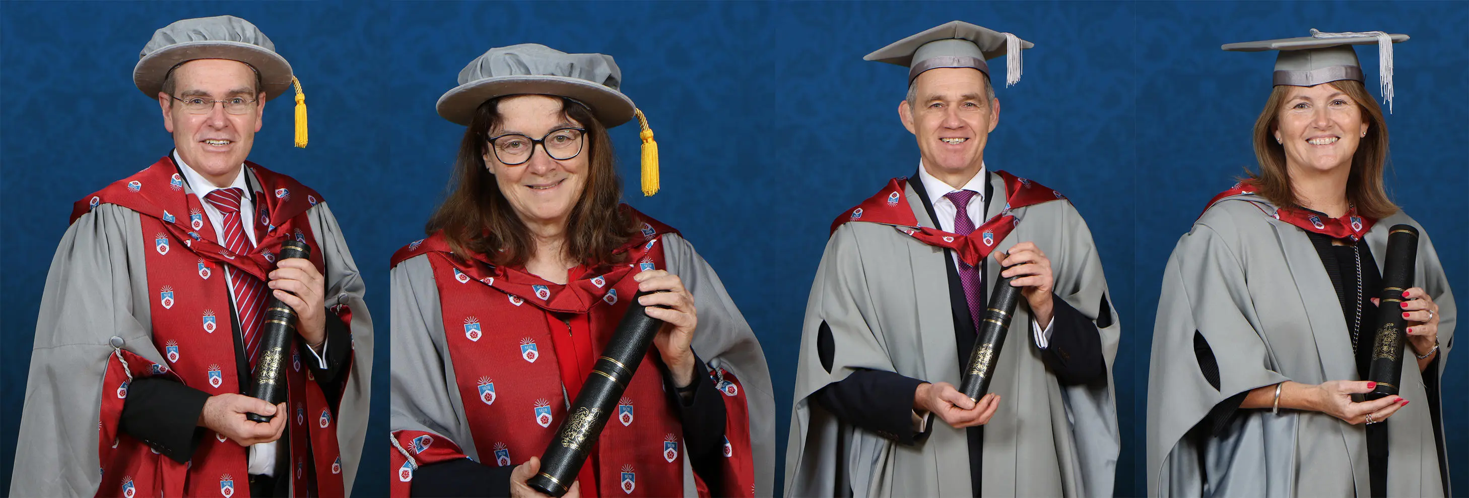 Four people dressed in academic caps and gowns