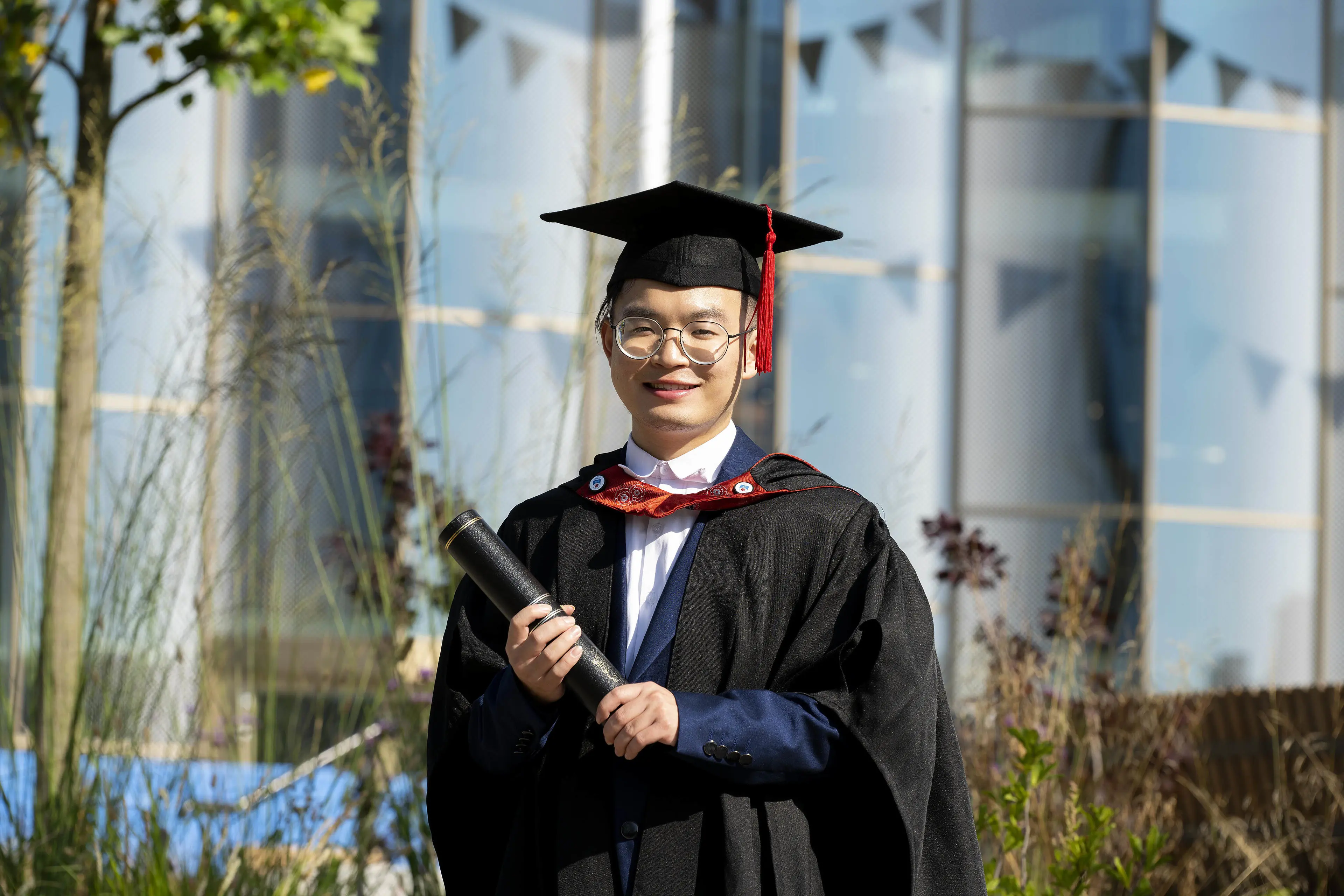 Hongming Jiang holding a graduation scroll