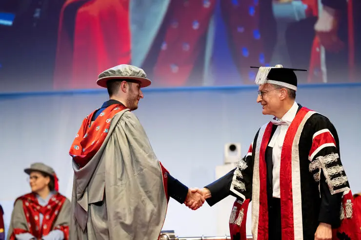Steven Gough-Kelly shaking hands on stage with VC Graham Baldwin