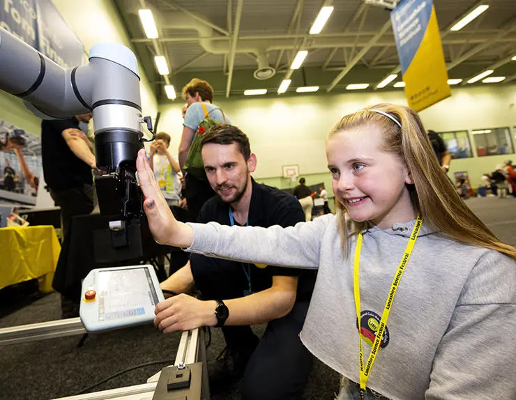 Chloe Spencer, 10, from Preston with AMRC project Engineer Ben Cheshire demonstrating the AMCR universal robot 