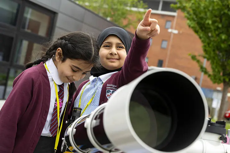 Aminah Patel, 9, (left) and Zaynab Member, 9, from Kennington Primary School learn how to use a telescope