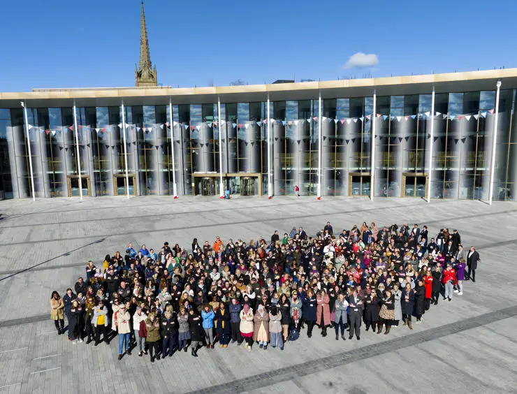 The group shot of everyone gathered on University Square, with the new Student Centre in the background