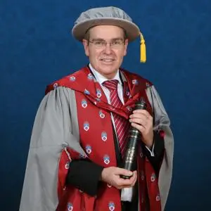 Honorary Doctorate Dave Holmes OBE holding a scroll