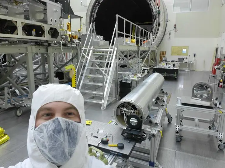 An optical engineer in the Engineering Directorate at NASA’s Marshall Space Flight Center in Huntsville, Alabama, grabs a selfie with the Marshall Grazing Incidence X-ray Spectrometer, or MaGIXS, during integrated payload testing at Marshall’s world-class X-ray and Cryogenic Facility. Credits: NASA