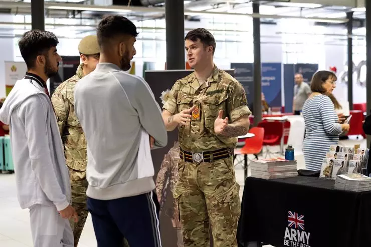 Members of the Army speaking to two students