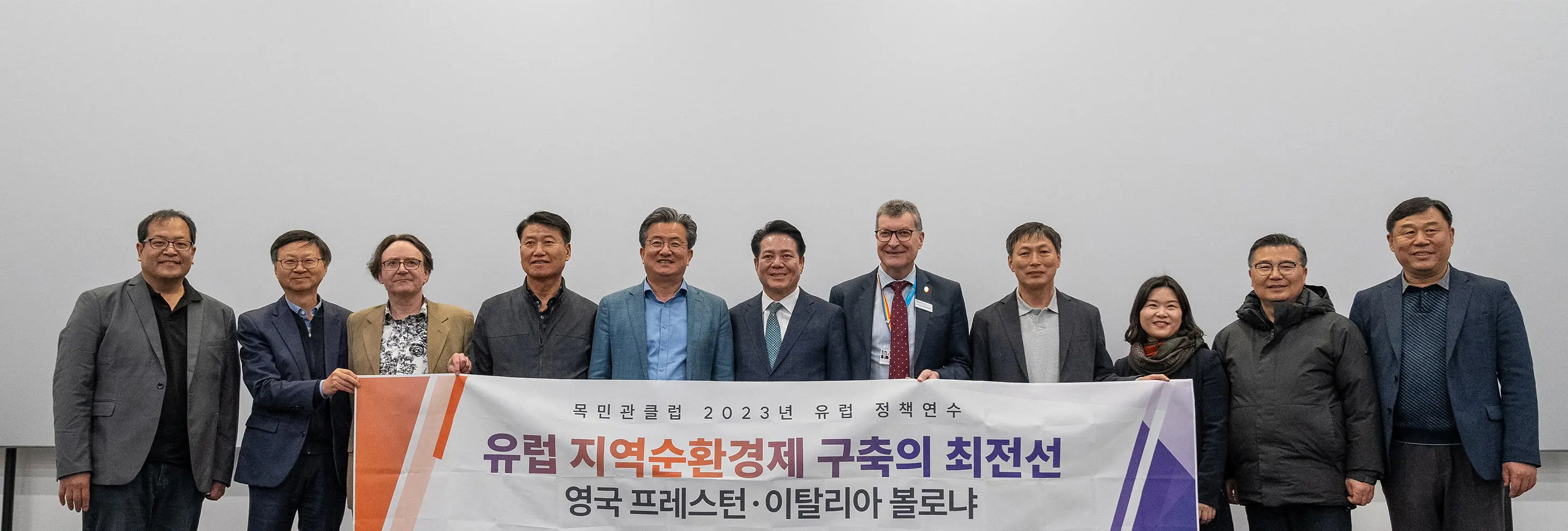 Image of South Korea delegation with Vice Chancellor Graham Baldwin holding banner